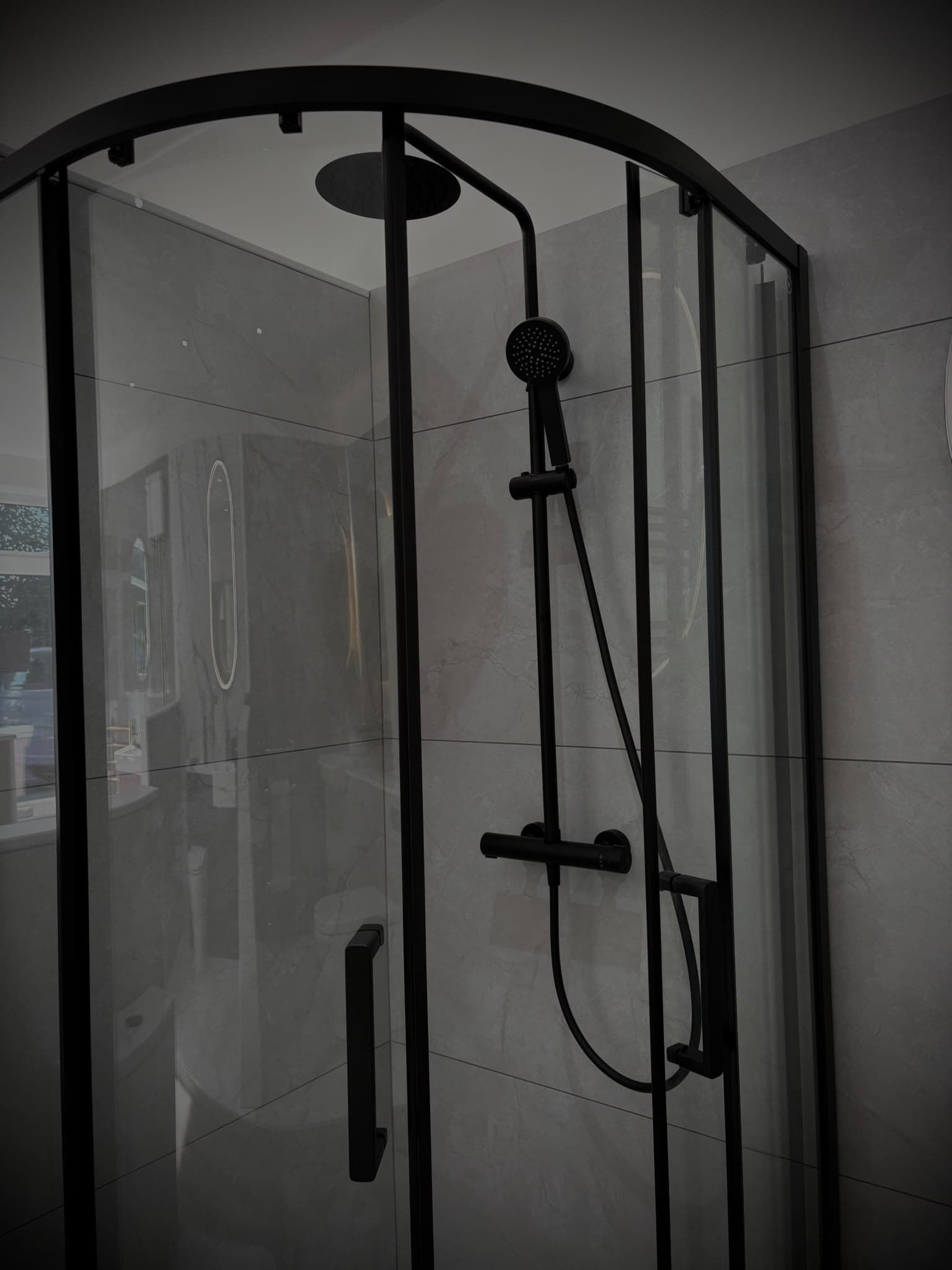 Matt black quadrant shower enclosure with rainfall head and thermostatic riser
