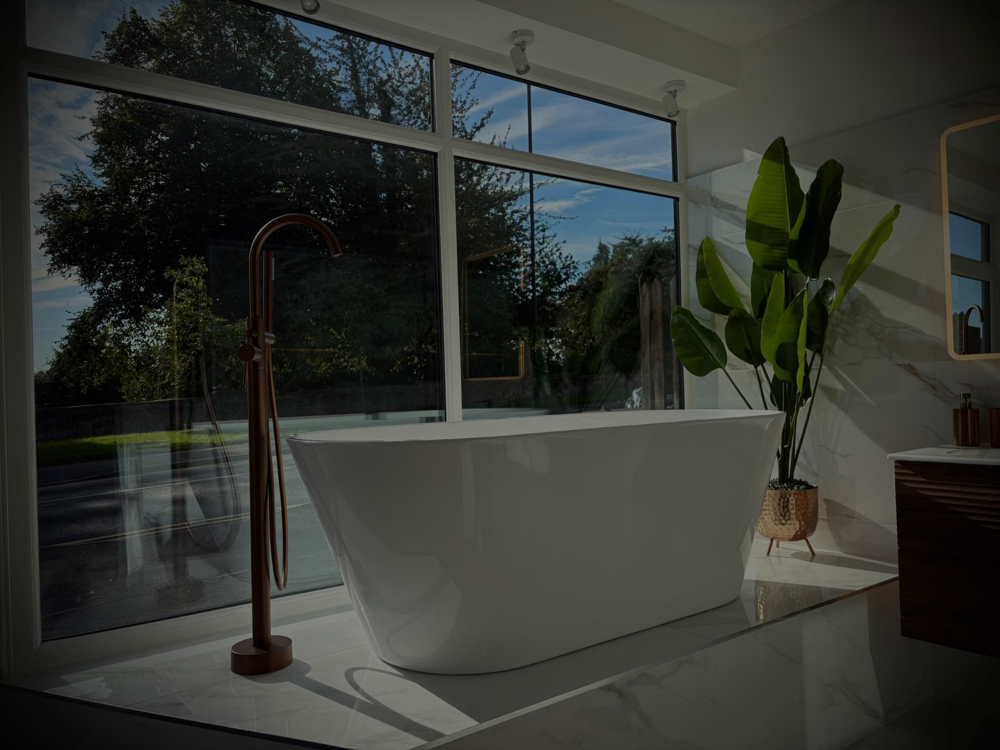Freestanding bath with copper floor-standing tap by the window at the S64 Bathrooms showroom in Mexborough