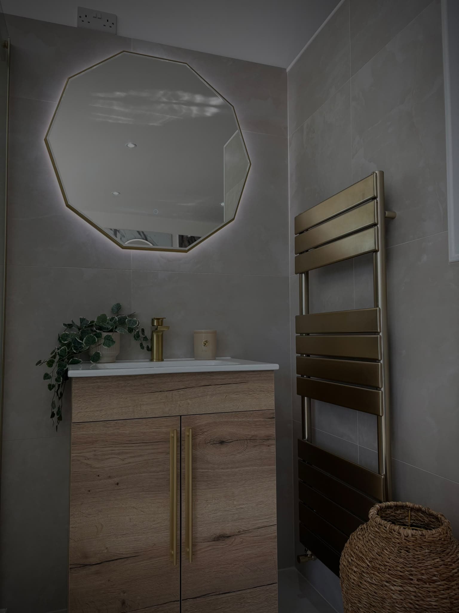 Oak vanity unit with brushed brass tap, decagon LED mirror and brass heated towel rail